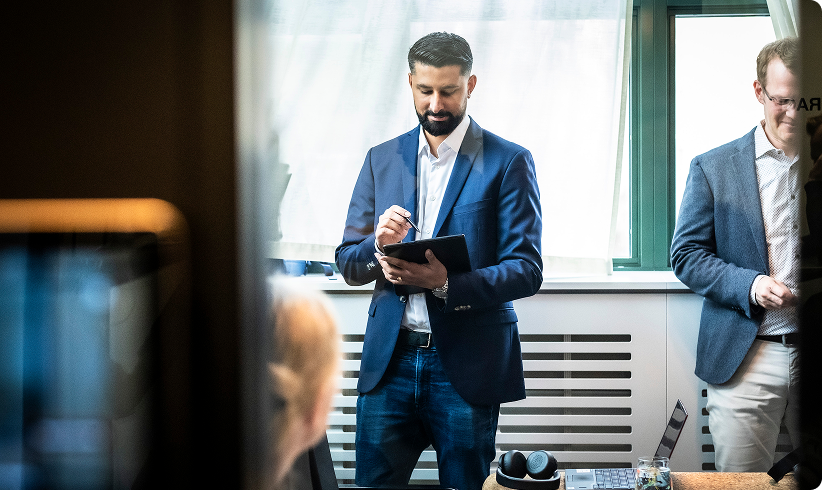 Professional office setting with man in blue suit holding tablet